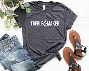 Puede incluir: Una camiseta gris oscuro con el texto "TREBLE MAKER" y un símbolo de clave de sol en blanco.