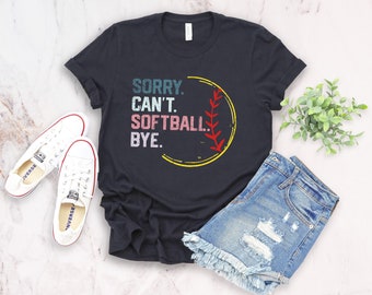 Puede incluir: Camiseta negra con un gráfico de estilo vintage de una pelota de softball y el texto "SORRY. CAN'T. SOFTBALL. BYE."