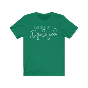 May include: A green t-shirt with the text "Half my heart is Deployed" in white.
