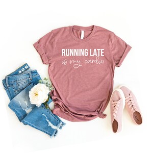 May include: A mauve t-shirt with the text "RUNNING LATE is my cardio" in white lettering.