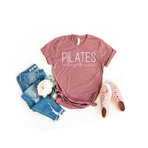 Peut inclure: Un t-shirt mauve avec le texte "PILATES is always the answer" en lettres blanches.