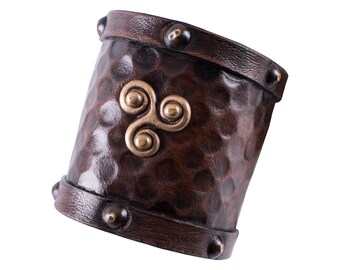 Small leather arm guard with Celtic triskel motif