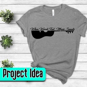 May include: Gray t-shirt with a black silhouette of a guitar and the text "When Words Fail, Music Speaks."