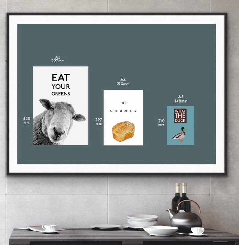 May include: Three framed prints with humorous text and illustrations. The first print is A3 size (297mm x 420mm) and features a black and white illustration of a sheep with the text "Eat Your Greens". The second print is A4 size (210mm x 297mm) and features a cartoon illustration of a slice of bread with the text "Oh Crumbs". The third print is A5 size (148mm x 210mm) and features a cartoon illustration of a duck with the text "What The Duck".