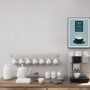 May include: A framed print with a blue background and white text that reads "FIRST I DRINK THE COFFEE THEN I DO THE THINGS". A cartoon illustration of a coffee cup with steam rising from it is below the text.