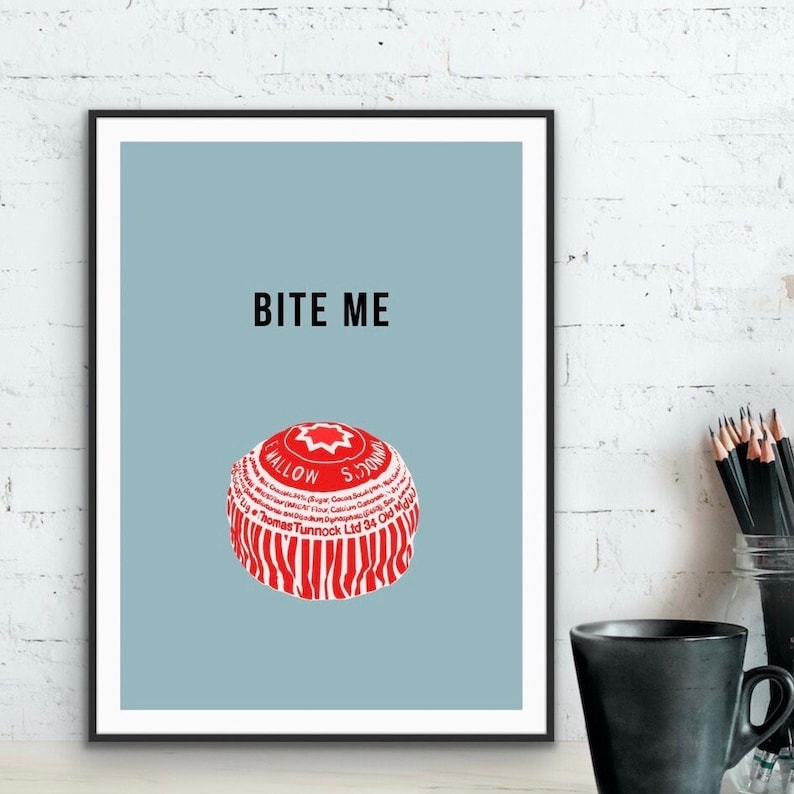 May include: A framed print with a blue background and the text "BITE ME" in black. A red and white candy with the text "S. DONNALLY'S MALLOW" is in the center of the print.