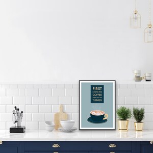 May include: A blue and white framed print with the text "FIRST I DRINK THE COFFEE THEN I DO THE THINGS" and a cartoon illustration of a steaming cup of coffee.