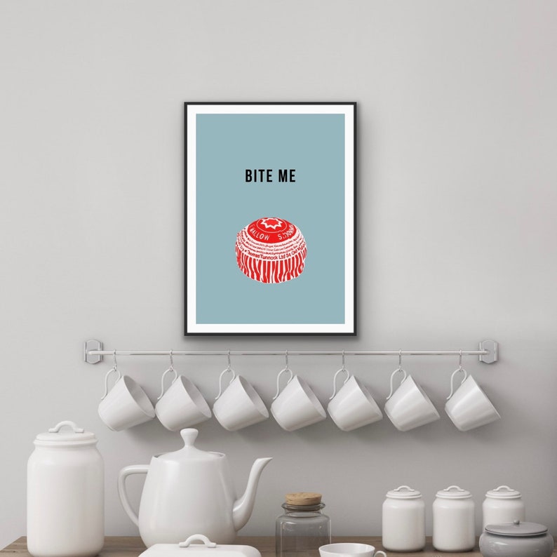 May include: A framed print with a light blue background and the text "BITE ME" in black. A red and white bottle cap is centered on the print.