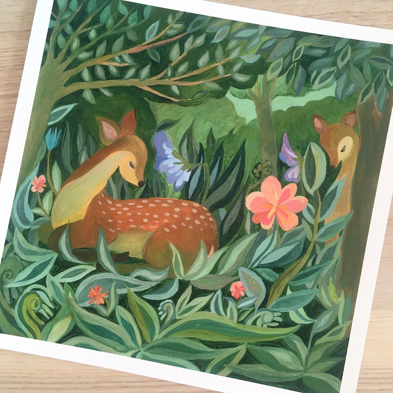 May include: A square art print featuring a painted scene of a brown fawn with white spots resting in a lush green forest. The composition includes dense foliage, large green leaves, a prominent pink flower, smaller orange blossoms, and a second deer.