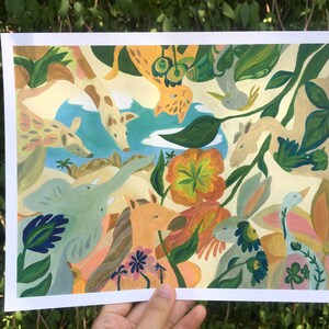 May include: A rectangular art print featuring a vibrant, multi-colored illustration of various animals including a giraffe, elephant, horse, and rabbit surrounded by stylized flowers and foliage against a light cream background with a blue sky.