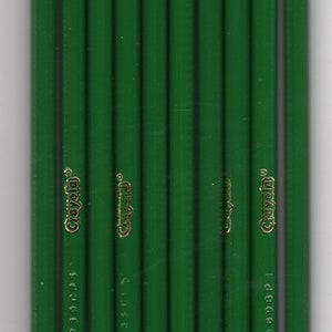 May include: A vertical shot of a group of green pencils with white tips. The pencils have the word "Crayola" in gold lettering. The pencils also have the words "green verde vert" printed on them.