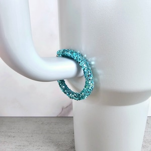 May include: A pair of turquoise hoop earrings with a sparkly finish.