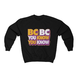 May include: Black sweatshirt with a graphic design that says "BC BC YOU KNOW YOU KNOW" in yellow, white, and purple letters.