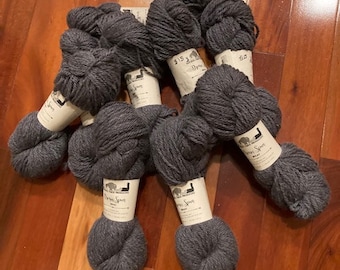 Puede incluir: Seis ovillos de lana gris oscuro con etiquetas blancas que dicen "The Loopy Ewe" y "Wool".