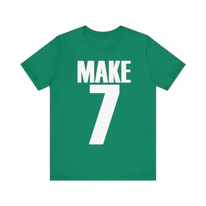 May include: A green t-shirt with white text that says "MAKE 7".