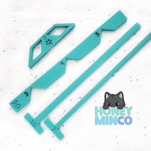 May include: A set of turquoise plastic tools for making polymer clay canes. The tools include a ruler with markings for 3, 5, 7, 10, 20, and a paw print design.