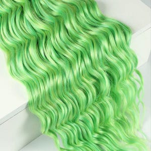 May include: Vibrant green wavy hair extensions. The synthetic hair features a blend of light and dark green shades, producing a lively and textured appearance. The hair is styled in loose waves, providing a voluminous look.