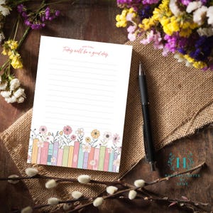 May include: A printable notepad with a lined page and a floral border. The notepad has the text "Today will be a good day" at the top. The border features a row of colorful books with flowers growing out of them.