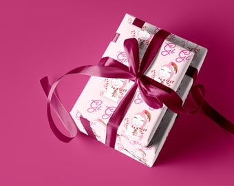May include: Two white gift boxes wrapped in pink and white wrapping paper with a unicorn design and the text "Gi Gi" on them. The boxes are tied with a burgundy satin ribbon.