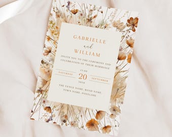 May include: Wedding invitation with a floral design featuring dried flowers in shades of brown, beige, and white. The text reads "Gabrielle and William" and includes the date and time of the wedding ceremony.