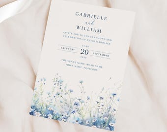 May include: A wedding invitation with a watercolor design of blue and white flowers. The invitation reads "Gabrielle and William invite you to the ceremony and celebration of their marriage. Saturday, September 20, 2030, 13:00. The Venue Name, Road Name. Town Name. Postcode."