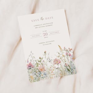 May include: A rectangular Save the Date card featuring a watercolour floral illustration at the bottom. The text reads: SAVE THE DATE, GABRIELLE AND WILLIAM ARE GETTING MARRIED, SATURDAY 20 SEPTEMBER 2030, 13:00, FORMAL INVITATION TO FOLLOW.