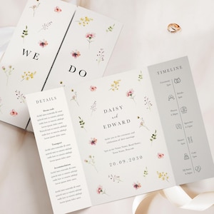 May include: Wedding invitation suite with floral details. The invitation includes the words "WE DO" and ceremony information. The design features a timeline and the names "Daisy and Edward".