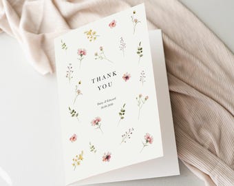 May include: A white thank you card with a floral design. The card has the words "Thank You" in black text and the date "20.09.2020" in smaller black text. The card is decorated with small pink and yellow flowers and green leaves.