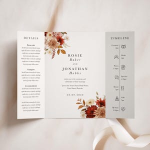 May include: A wedding invitation featuring a floral design in shades of red, orange, and white. The invitation includes the names "Rosie Baker" and "Jonathan Hobbs" and the date "20.09.2030". The invitation also includes a timeline of events for the wedding day.