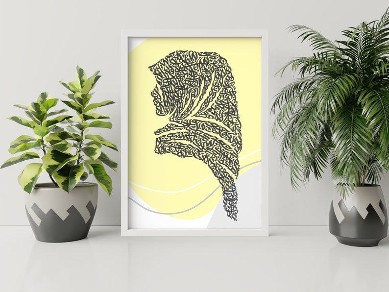 May include: A framed print with a yellow background and a black silhouette of a woman's head and shoulders. The silhouette is made up of intricate calligraphy.