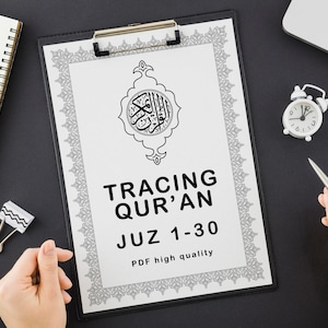 Puede incluir: Un portapapeles negro sostiene una hoja blanca con caligrafía negra adornada y el texto "TRACING QUR'AN JUZ 1-30 PDF high quality". También se ven un pequeño reloj blanco y un cuaderno.