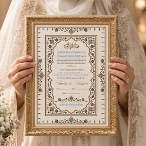 May include: A rectangular marriage certificate in an ornate gold frame featuring intricate blue and gold floral borders. The document includes Arabic calligraphy, English text stating 'THIS AGREEMENT MADE' and 'AMIRA & KAREEM', with blank lines for signatures.