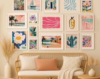 May include: A gallery wall of framed art prints featuring colorful illustrations. The artwork includes beach scenes, flowers, a sailboat, and abstract designs. The wall is above a rattan sofa with pillows and a blanket, creating a cozy, artistic living space.
