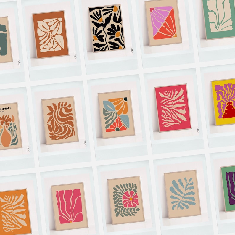 May include: A collection of framed art prints featuring abstract floral designs in various colors. The prints showcase botanical shapes in shades of orange, black, pink, and blue, set against neutral backgrounds. The art pieces are displayed in a grid.