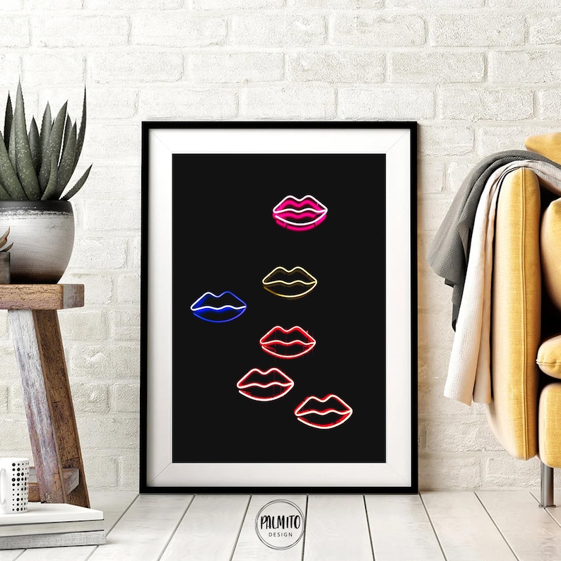 Peut inclure: Une impression encadr&eacute;e en noir et blanc avec un fond noir et un motif de six l&egrave;vres au n&eacute;on de diff&eacute;rentes couleurs, dont le rose, le rouge, le bleu et le jaune. Les l&egrave;vres sont dispos&eacute;es en un motif vertical, les l&egrave;vres roses en haut et les l&egrave;vres jaunes en bas.
