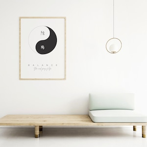 May include: A framed print with a black and white yin yang symbol and the text "BALANCE Yin and yang of life". The print is hanging on a white wall above a light green couch.