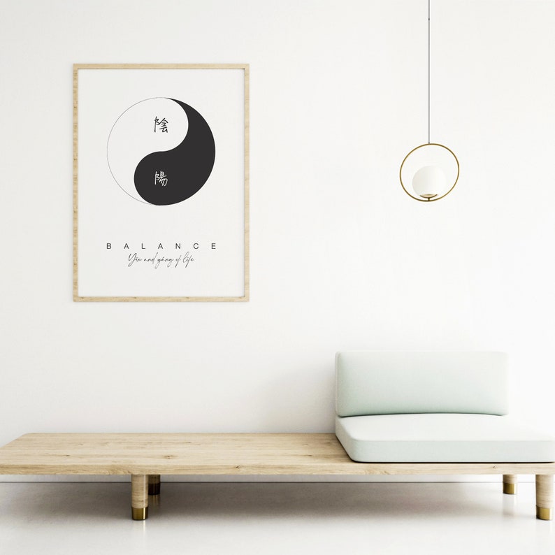 May include: A framed print with a black and white yin yang symbol and the text "BALANCE Yin and yang of life". The print is hanging on a white wall above a light green couch.