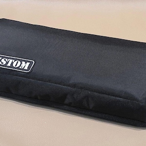以下が含まれることがあります： 「CUSTOM」と白く書かれたラベルが付いた、黒いカスタムキャリーケースです。