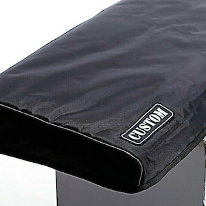 May include: Black cover with white trim and the word "CUSTOM" in a white rectangle. The cover appears to be made of a durable, water-resistant material. The cover is designed to fit a rectangular object.
