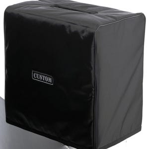 May include: Black custom amp cover with a zipper and a silver label that says "CUSTOM".