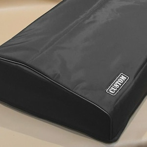 Könnte beinhalten: Eine schwarze, rechteckige Hülle mit abgerundeter Oberseite und einer genähten Bordüre. Das Wort "CUSTOM" ist in einem weißen Rechteck auf der Seite aufgedruckt. Die Hülle scheint aus einem glatten, strapazierfähigen Stoff zu sein.