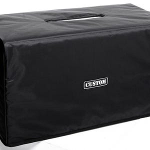 May include: Black amp cover with a handle and the word "CUSTOM" printed on the front.
