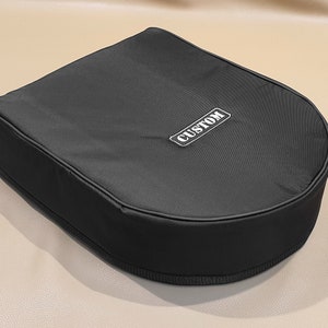 Puede incluir: Estuche negro hecho a medida con la palabra "CUSTOM" bordada en blanco en la parte superior.