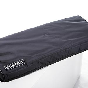 May include: A rectangular black protective cover with a smooth, matte finish and piped edges. A small, rectangular black label with a white border and the word CUSTOM in white capital letters is stitched onto the lower left corner of the cover.
