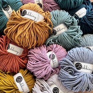 May include: A variety of colours of cotton cord, each spool labelled "Bobbiny Premium 5mm", in a close-up image.