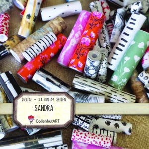 Könnte beinhalten: Eine Sammlung bunter, gemusterter Papierrollen. Designs umfassen florale, abstrakte und geometrische Muster in Pink, Orange, Grün und Schwarz. Ein Etikett mit dem Namen "SANDRA" und "BollenhutART" ist sichtbar.