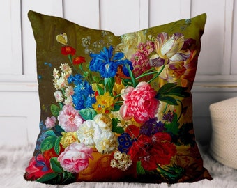 May include: A colorful floral pillow featuring a bouquet of flowers in a vase. The flowers include pink, red, white, blue, yellow, and purple blooms. The background is a dark green.