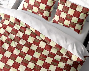 May include: A red and cream checkered duvet cover with two matching pillowcases. The duvet cover has a subtle brushstroke pattern.