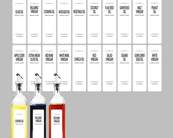 Puede incluir: Tres botellas de vidrio con boquillas y etiquetas. Las botellas están llenas de aceite de cocina, vinagre balsámico y vinagre de vino tinto. Las etiquetas son blancas con texto negro y enumeran el contenido de cada botella.