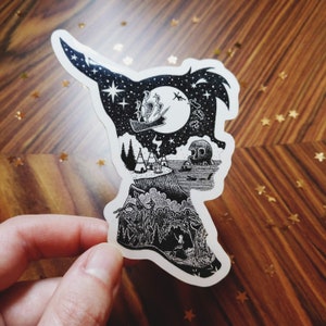 May include: A die-cut sticker shaped like a silhouette of a head in profile, filled with a detailed black and white illustration. The design features a night sky with a ship, a full moon, a campfire, teepees, a skull rock, and a forest scene.